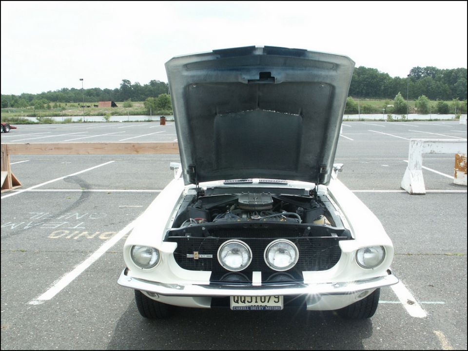 White 1969 Ford Mustang with hood open, front view