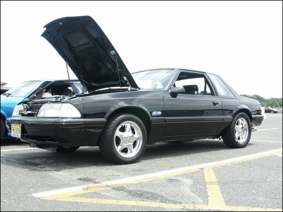 Black Fox body Mustang coupe with hood open, parked next to a blue car