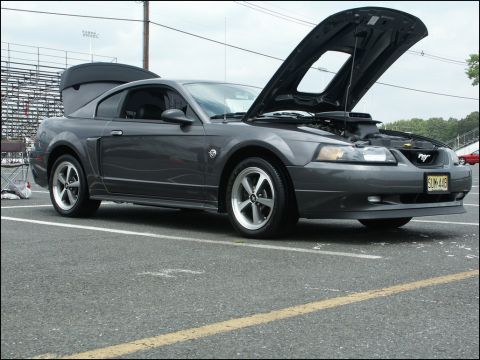 2001 Mercury Grand Marquis - A dark gray Ford Mustang is parked with its hood and trunk open, revealing the engine and interior space.