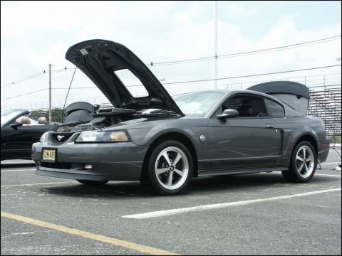 2001 Mercury Grand Marquis - This gray coupe, likely a Ford Mustang from the early 2000s, is displayed with its hood and trunk open at a car show.