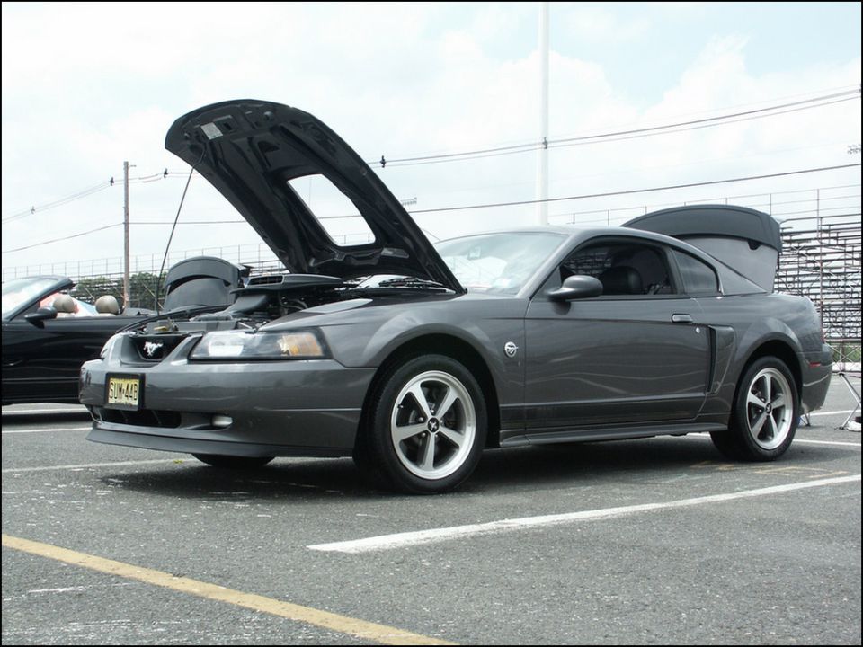Gray coupe with hood and trunk open, showing engine and interior