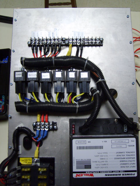 2004 Ford Crown Victoria - Custom-built electrical panel on an aluminum plate for emergency-vehicle equipment: a terminal strip feeding six labeled automotive relays…