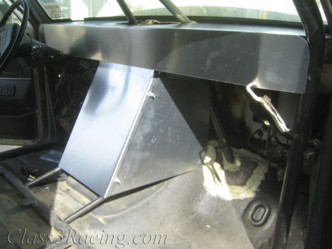 1990 Ford Bronco - Fabricated bare sheet-metal console and dash structure mounted inside a stripped vehicle cab with foam-sealed floor opening.