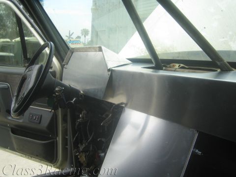 1990 Ford Bronco - Interior of a gutted vehicle showing a bare aluminum dash structure and steering wheel over loose wiring.