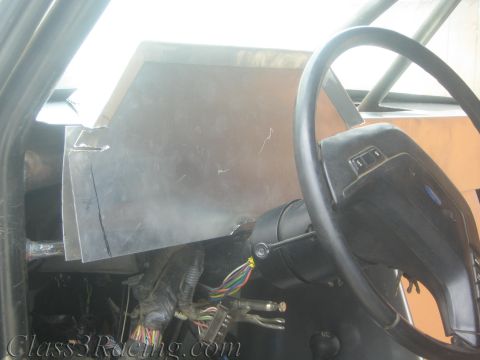1990 Ford Bronco - Unpainted dash panel and Ford steering wheel inside a stripped cabin, with colored wiring exposed below.