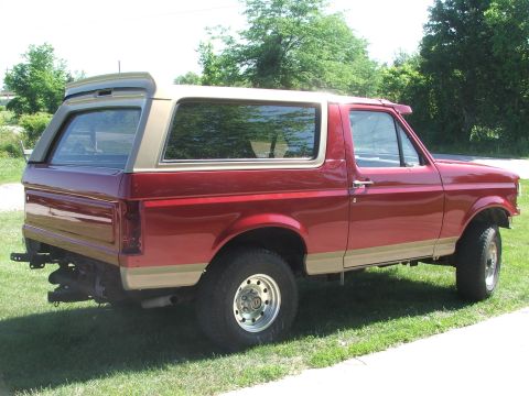 1994 Ford Bronco - Red 1992 Ford Bronco with tan accents, seen from the rear passenger side.