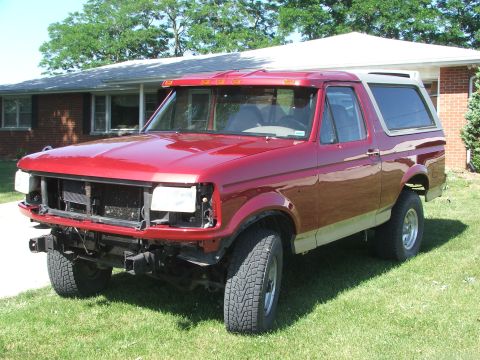 1994 Ford Bronco - This red Ford Bronco is missing its front bumper and grille, showing its inner workings.