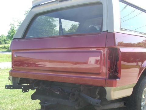 1994 Ford Bronco - Rear view of a 1994 Ford Bronco undergoing restoration, showing the quarter panel and missing bumper.