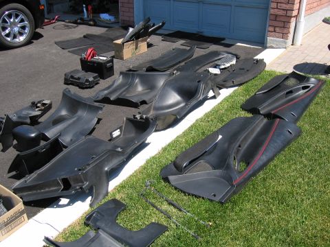 1993 Ford Probe - Various car interior parts are laid out on the grass and driveway.