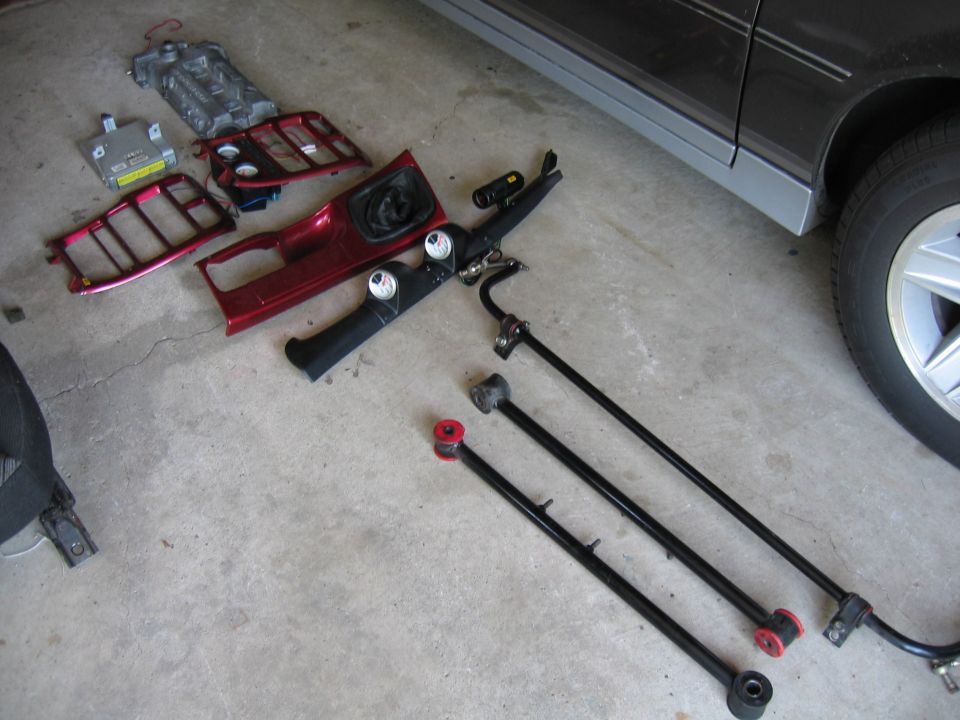 Red interior trim piece and suspension parts on concrete