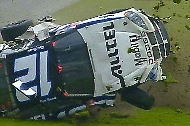 1981 Ford Bronco - A race car lies on its side after an apparent crash, with 'DODGE' and 'ALLTEL' branding clearly visible.