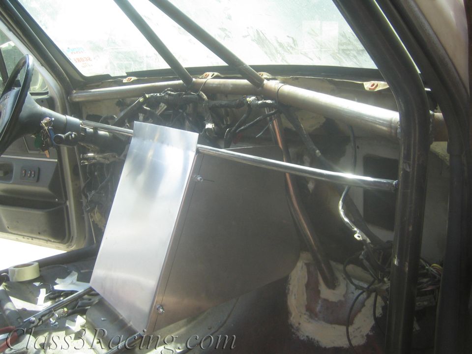 Aluminum dash box mounted to roll cage in a stripped vehicle interior