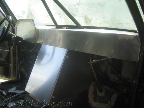 1990 Ford Bronco - long bare aluminum dash panel mounted across the front of a gutted vehicle interior over exposed components.