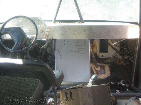 1990 Ford Bronco - fabricated aluminum dash marked with gauge-opening circles and handwritten notes inside a gutted vehicle.