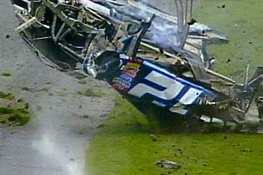 1981 Ford Bronco - A race car is shown upside down and heavily damaged after an apparent crash on a grassy area.