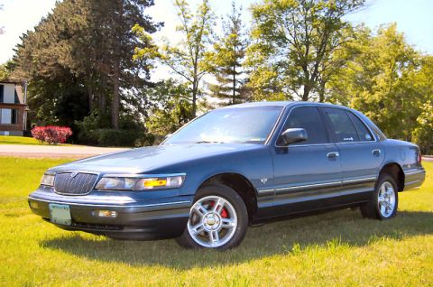 1985 Mercury Grand Marquis - This sedan, likely a 1995 model, is shown in a 3/4 front view with its red brake calipers visible.