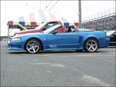 2001 Mercury Grand Marquis - Side view of a blue convertible sports car parked at an outdoor event.