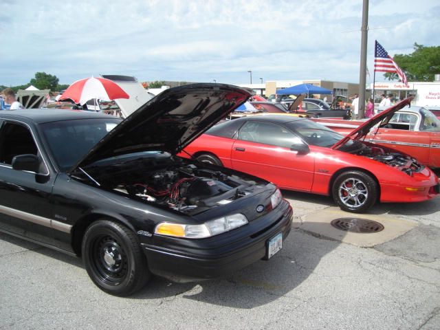 Black 1992 Ford Crown Victoria, front 3/4 view, hood open, parked at car show