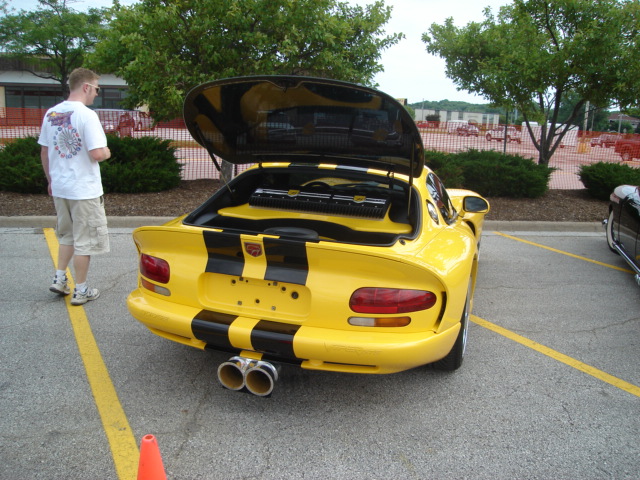 Yellow sports car with black stripes and open trunk showing audio equipment
