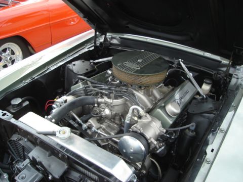 1992 Ford Crown Victoria - The engine bay of a classic car is open, revealing a V8 engine and other components, with another vehicle in the background.