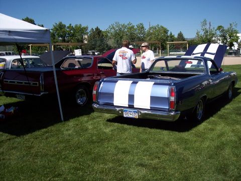 1972 Ford Ranchero - Two Ford Rancheros, a blue one with stripes and a red one, are parked on a grassy field under a tent.