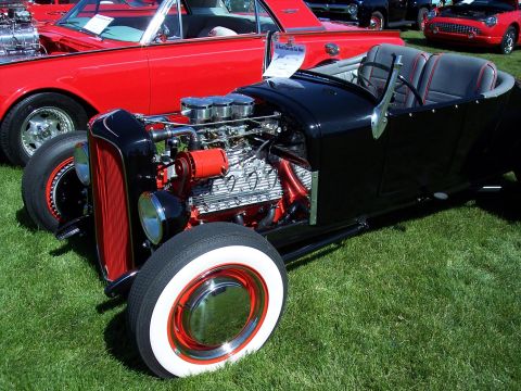 1972 Ford Ranchero - A custom hot rod roadster is parked on the grass next to other vehicles at an outdoor event.