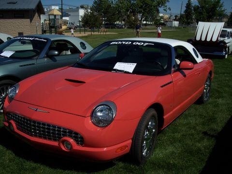 1972 Ford Ranchero - Red 2002-2005 Ford Thunderbird convertible with a white top and "BOND 007" windshield sticker.