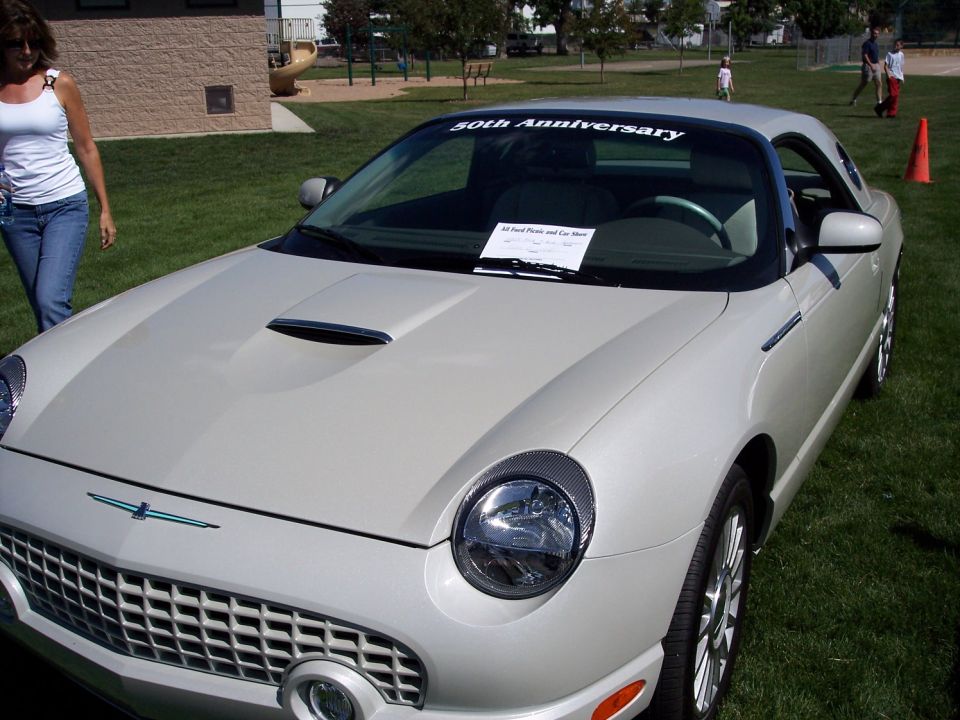 White 2002 Ford Thunderbird with a "50th Anniversary" banner on the windshield