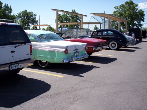 1972 Ford Ranchero - Several vintage automobiles are lined up in a parking lot on a sunny day.