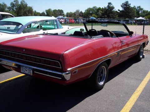1972 Ford Ranchero - A red convertible is parked next to another classic car at an outdoor event.