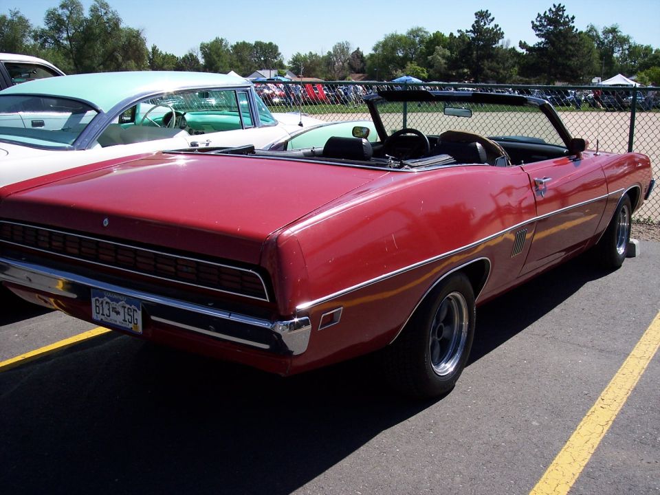 Red convertible parked next to a teal and white classic car