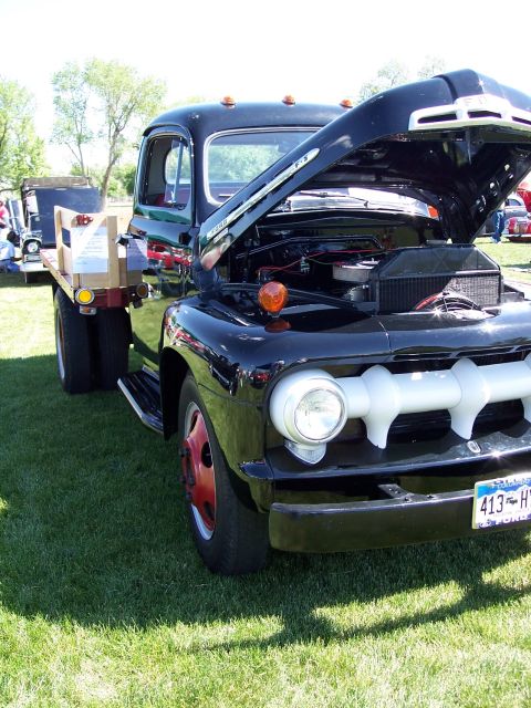 1972 Ford Ranchero - Black 1951 Ford F-series truck with hood open and red wheels on display at an outdoor event.