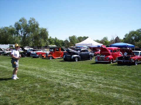 1972 Ford Ranchero - A gathering of vintage automobiles displayed on a grassy field under a clear blue sky.