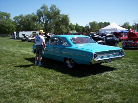 1972 Ford Ranchero - A turquoise 1964 Ford Galaxie 500 coupe is displayed at an outdoor car show with other vehicles present vehicles.