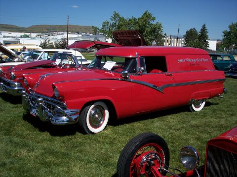 1972 Ford Ranchero - A red sedan delivery van is parked on grass at an outdoor car show with other vehicles present.