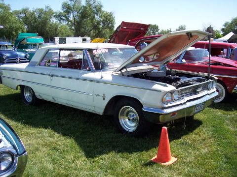 1972 Ford Ranchero - A white 1963 Ford Galaxie 500 is displayed with its hood open at an outdoor event, with other vehicles visible in the background.
