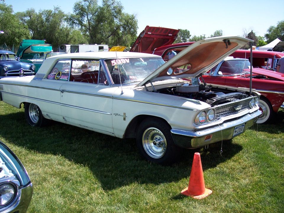 White 1963 Ford Galaxie 500 with hood open, parked on grass