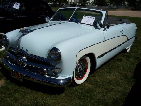 1972 Ford Ranchero - Light blue 1950 Ford convertible parked on grass, with a black car partially visible behind it.