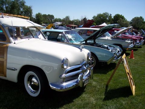 1972 Ford Ranchero - A line of classic cars are displayed on a sunny day at an outdoor event.