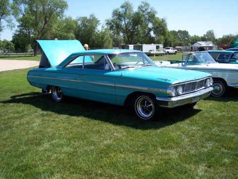 1972 Ford Ranchero - A turquoise 1963 Ford Galaxie is displayed outdoors with its hood open, alongside other vehicles.
