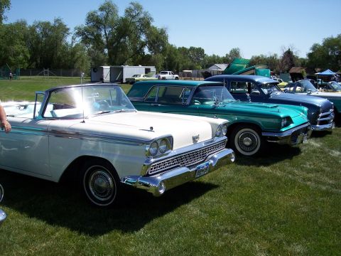 1972 Ford Ranchero - A line of classic cars, including a white convertible, are displayed on a grassy field under a clear blue sky.