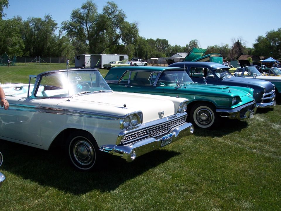 White 1959 convertible with chrome grille and dual headlights parked on grass