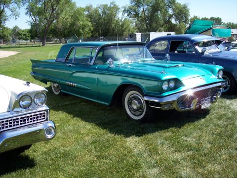 1972 Ford Ranchero - A classic teal Ford Thunderbird is displayed at an outdoor event with other vintage vehicles.