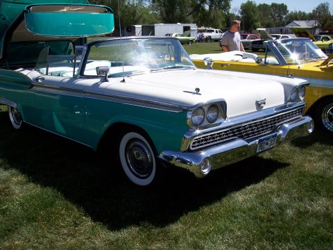 1972 Ford Ranchero - A classic 1959 Ford Fairlane 500 Skyliner convertible is parked on grass next to a yellow car.