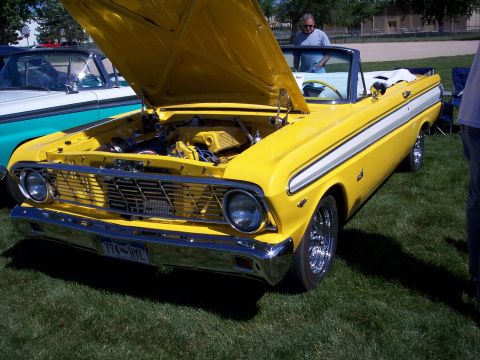 1972 Ford Ranchero - A yellow convertible is displayed with its hood open, parked on a grassy area.