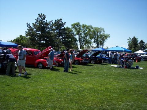 1972 Ford Ranchero - A sunny day at a car show features multiple vehicles and attendees mingling on the grass.