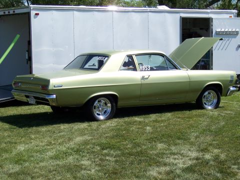 1972 Ford Ranchero - A light green coupe sits on a grassy field with its hood open, adjacent to a white trailer.
