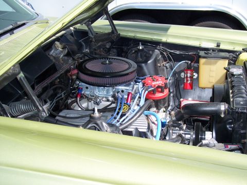 1972 Ford Ranchero - The engine bay of a light green vehicle shows a V8 engine with aftermarket parts.