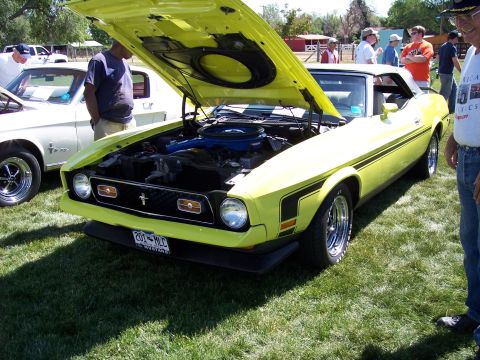 1972 Ford Ranchero - A yellow 1971 Ford Mustang convertible is displayed with its hood open at an outdoor event.