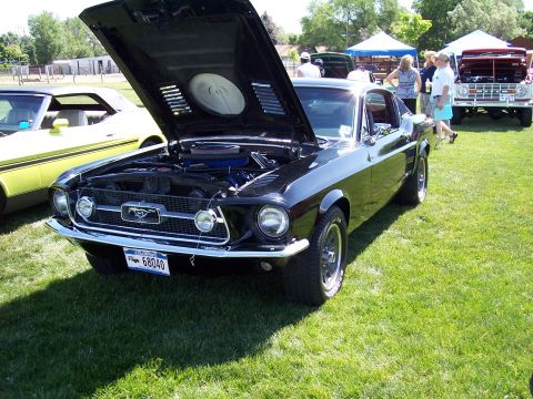 1972 Ford Ranchero - A black 1967 Ford Mustang is displayed with its hood open at an outdoor car show.